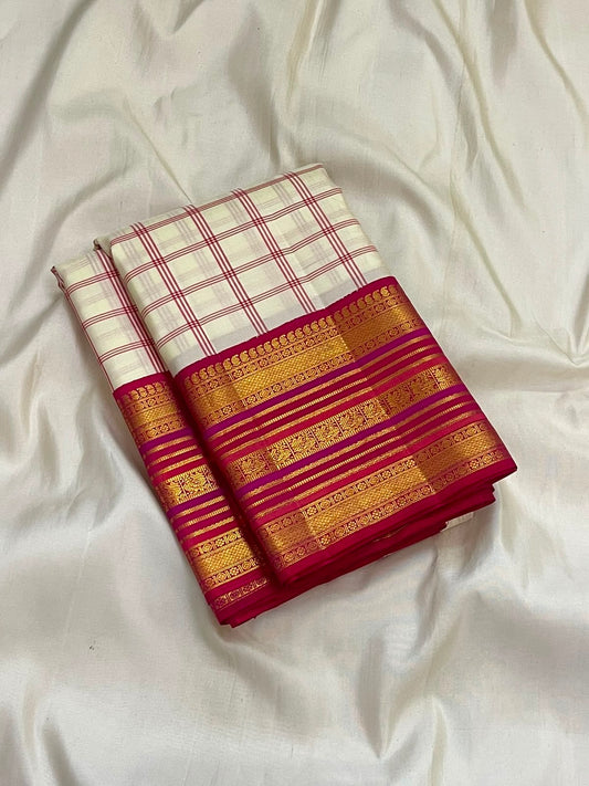 Gold zari border detail on the ivory raspberry pink Kanchipuram saree