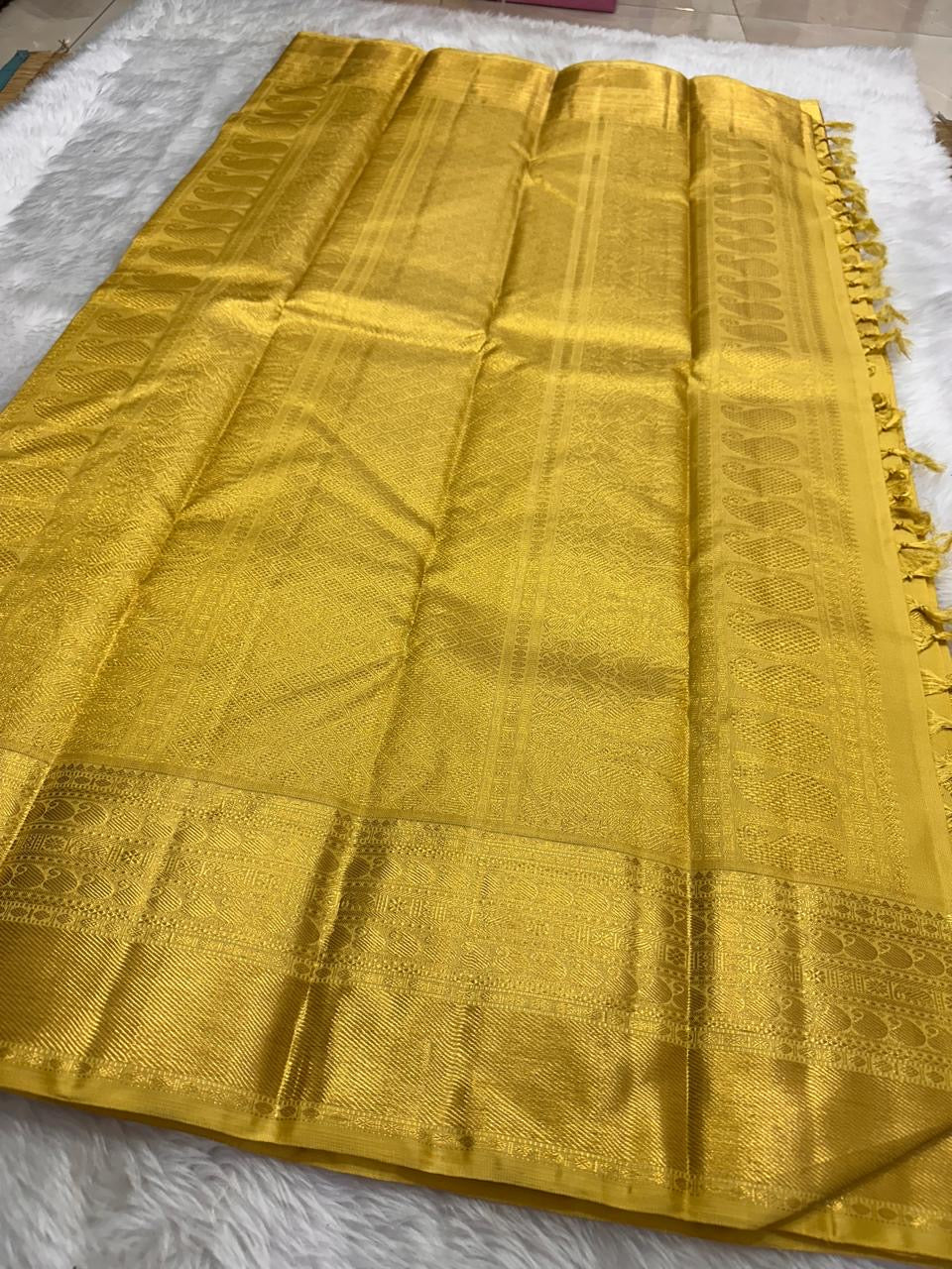 Folded border detail showing layered gold zari registers and richly woven ornamental motifs