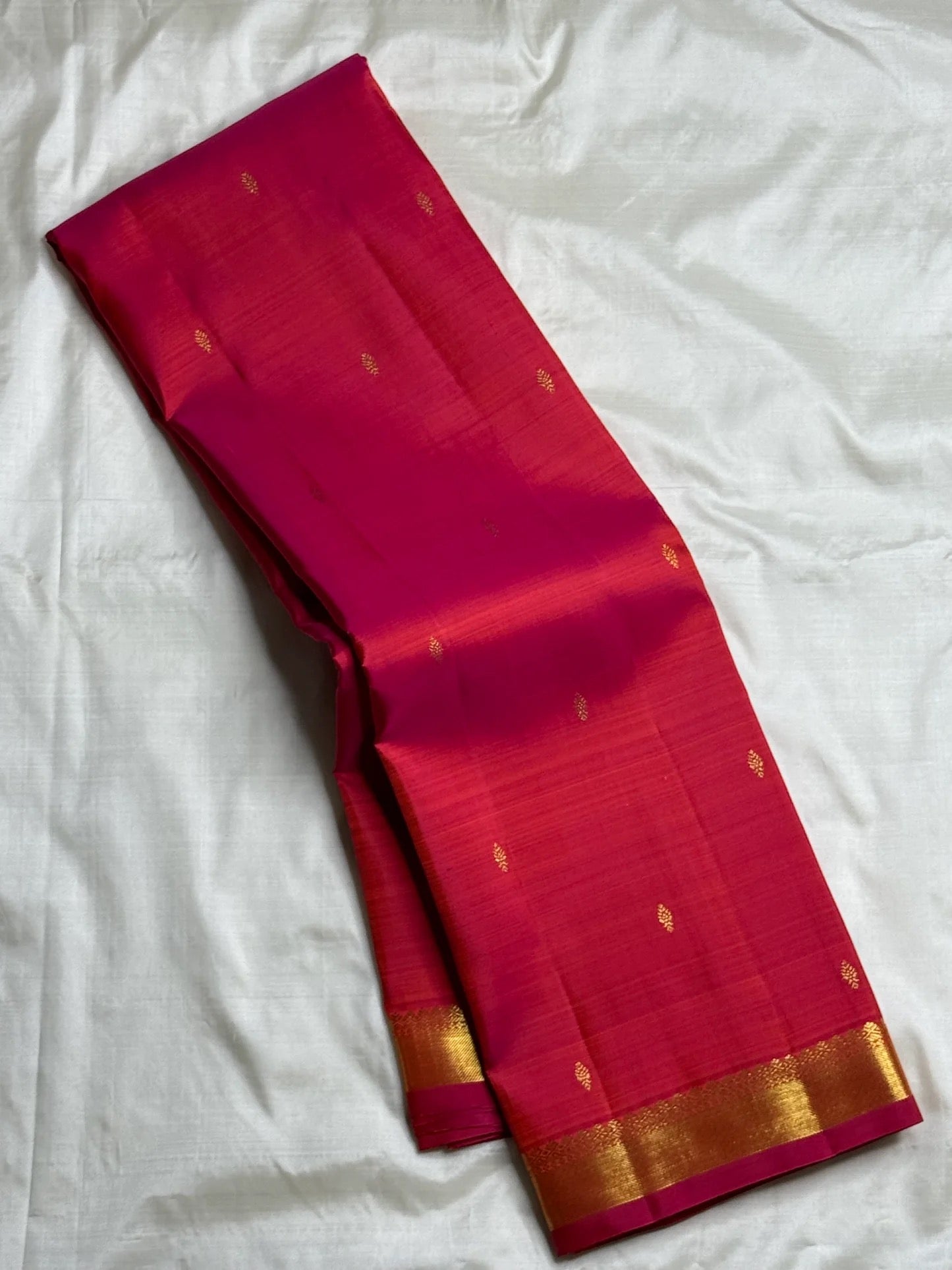 Gold zari butta detail on Rani Pink Kanchipuram silk with warm coral-orange colour movement
