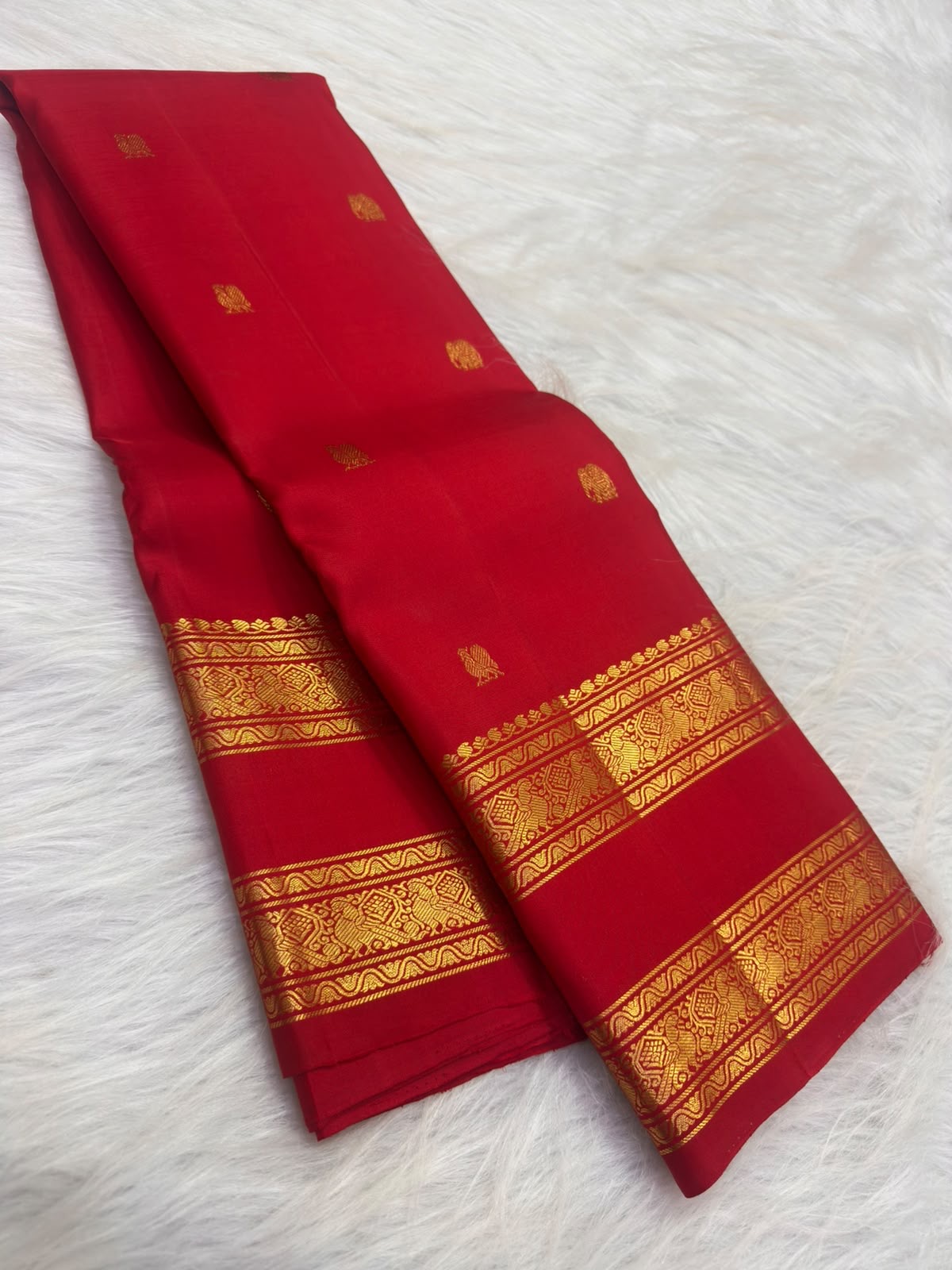 Gold zari buttas on the deep raspberry pink Kanjipuram Rettapet saree body