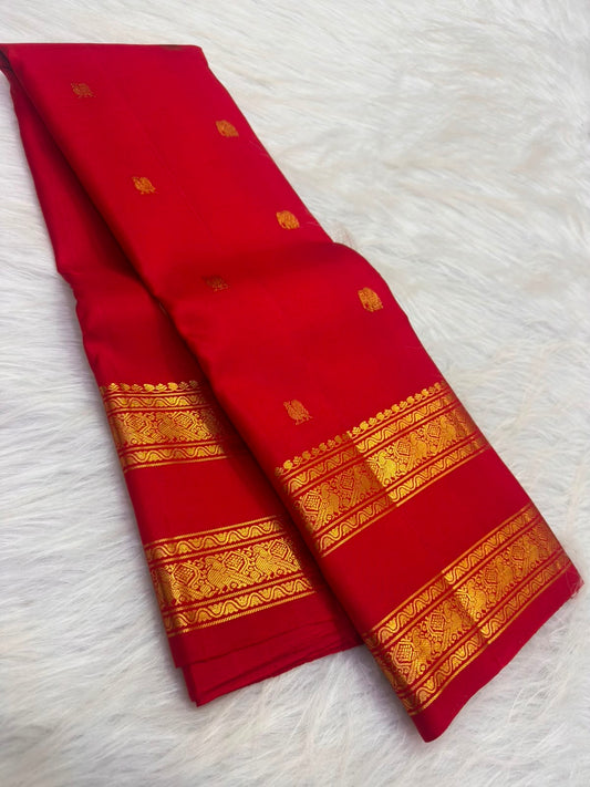 Gold zari buttas on the deep raspberry pink Kanjipuram Rettapet saree body