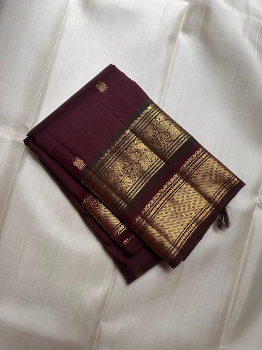 Close-up of gold zari buttas on Deep Plum Kancheepuram silk saree body
