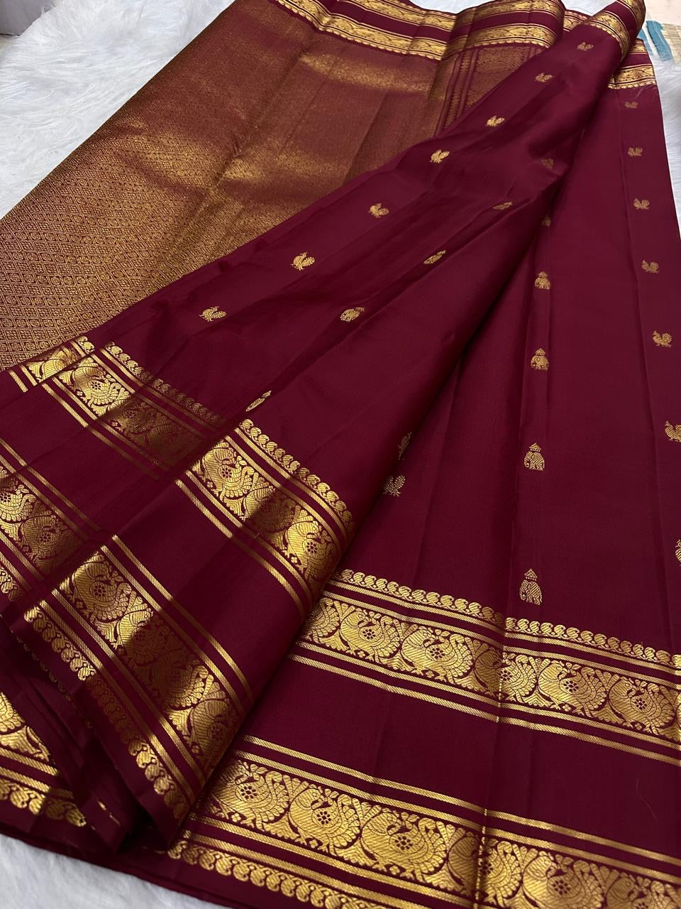 Gold zari mango buttas on the deep maroon Kanchipuram saree body