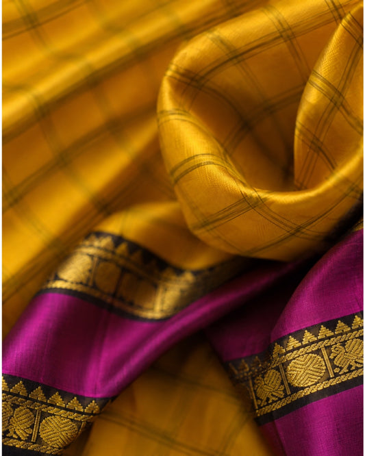 Handwoven Kanjivaram silk saree in golden mustard yellow with traditional zari and purple contrast border