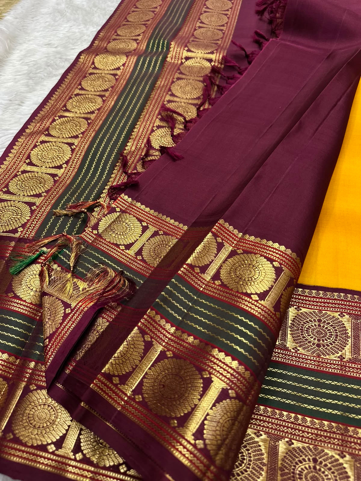Golden yellow Kanjipuram silk saree with deep maroon border close-up