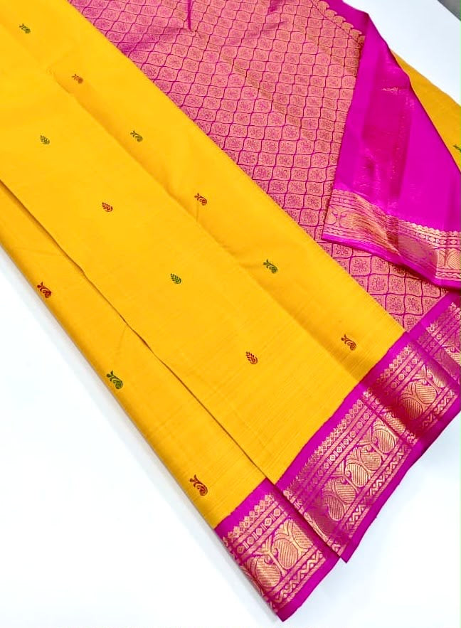 Golden-yellow Korvai saree showing petal-pink and deep-green Ganga Jamuna borders