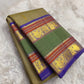 Moss Green Shot Silk pure silk Kanchipuram saree, silk body, showing muted olive-moss and sage green shot with golden undertones, brighter emerald pallu, deep cobalt-blue silk-thread accents, copper-rust bands and antique-gold zari