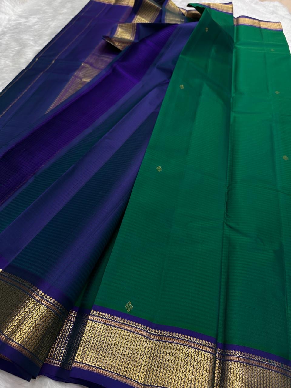 Emerald Green and Neelam Violet-Blue lightweight Kanchipuram silk saree, geometric gold zari border and patterned violet-blue pallu; border detail