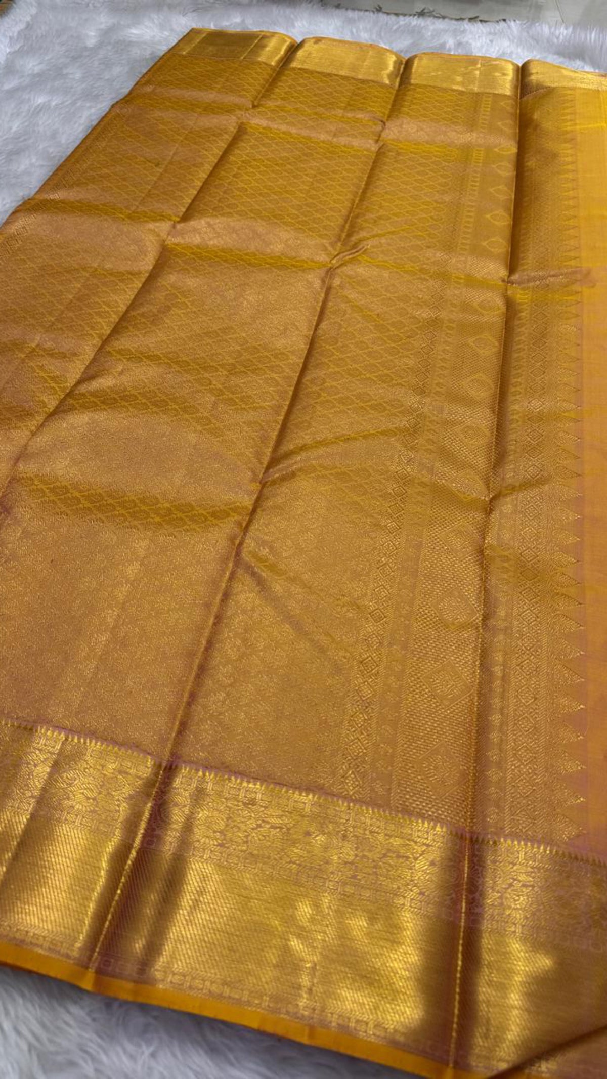 Sunset orange Kanchipuram silk saree, pallu with fine gold zari lattice and yellow-gold striping