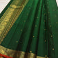 Close view of antique-gold zari buttas on Deep Emerald Green Kanjivaram silk.