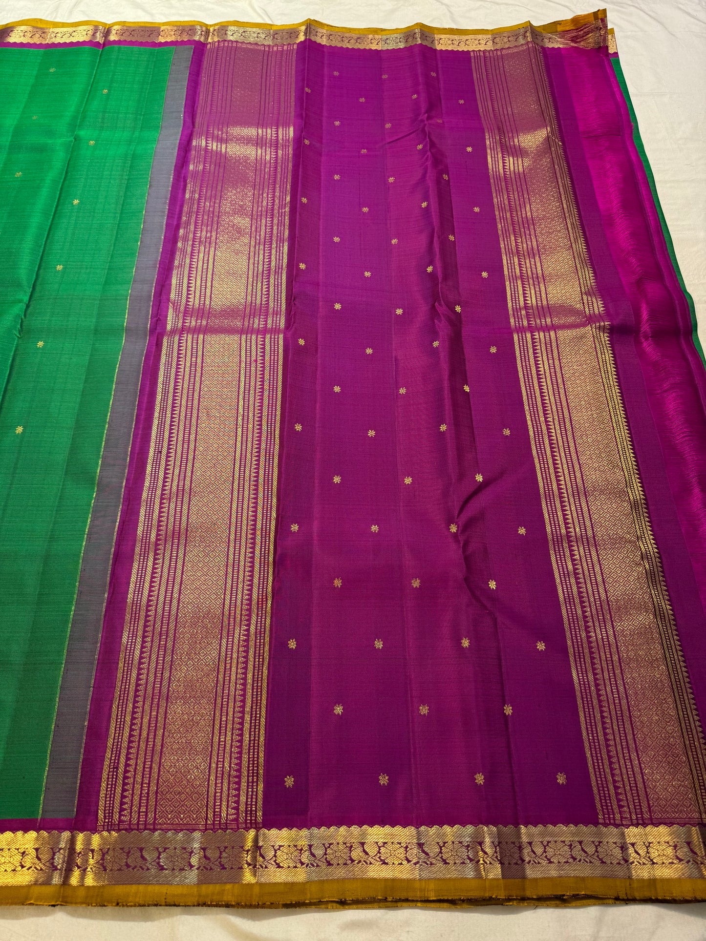 Close-up of Kamalam Butta gold-zari motifs on green Kancheepuram silk body