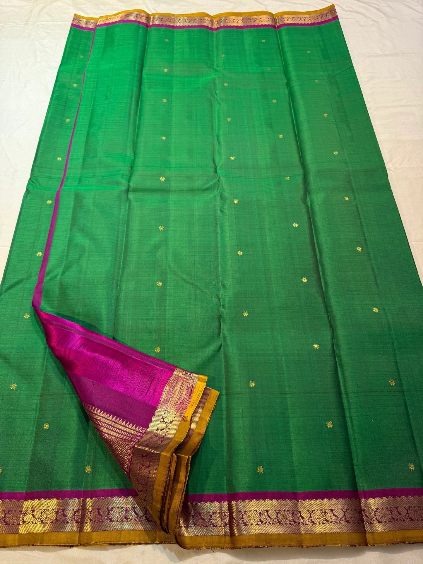 Magenta petite border with fine gold zari edge on green Kancheepuram saree