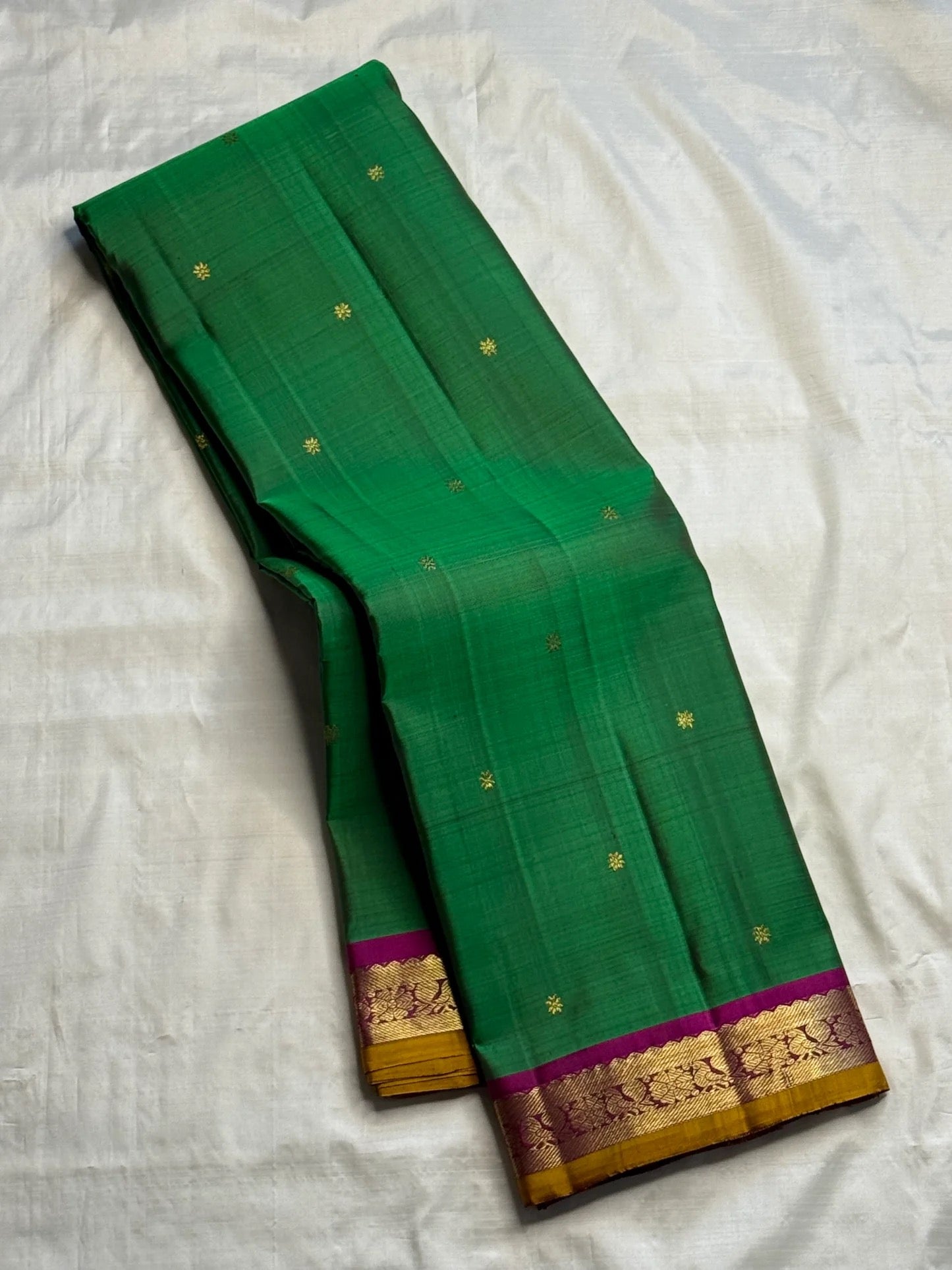 Green Butta Kancheepuram silk saree folded, showing full drape and border