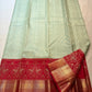Pista green Butta Kanchipuram silk saree draped, showing the red contrast border