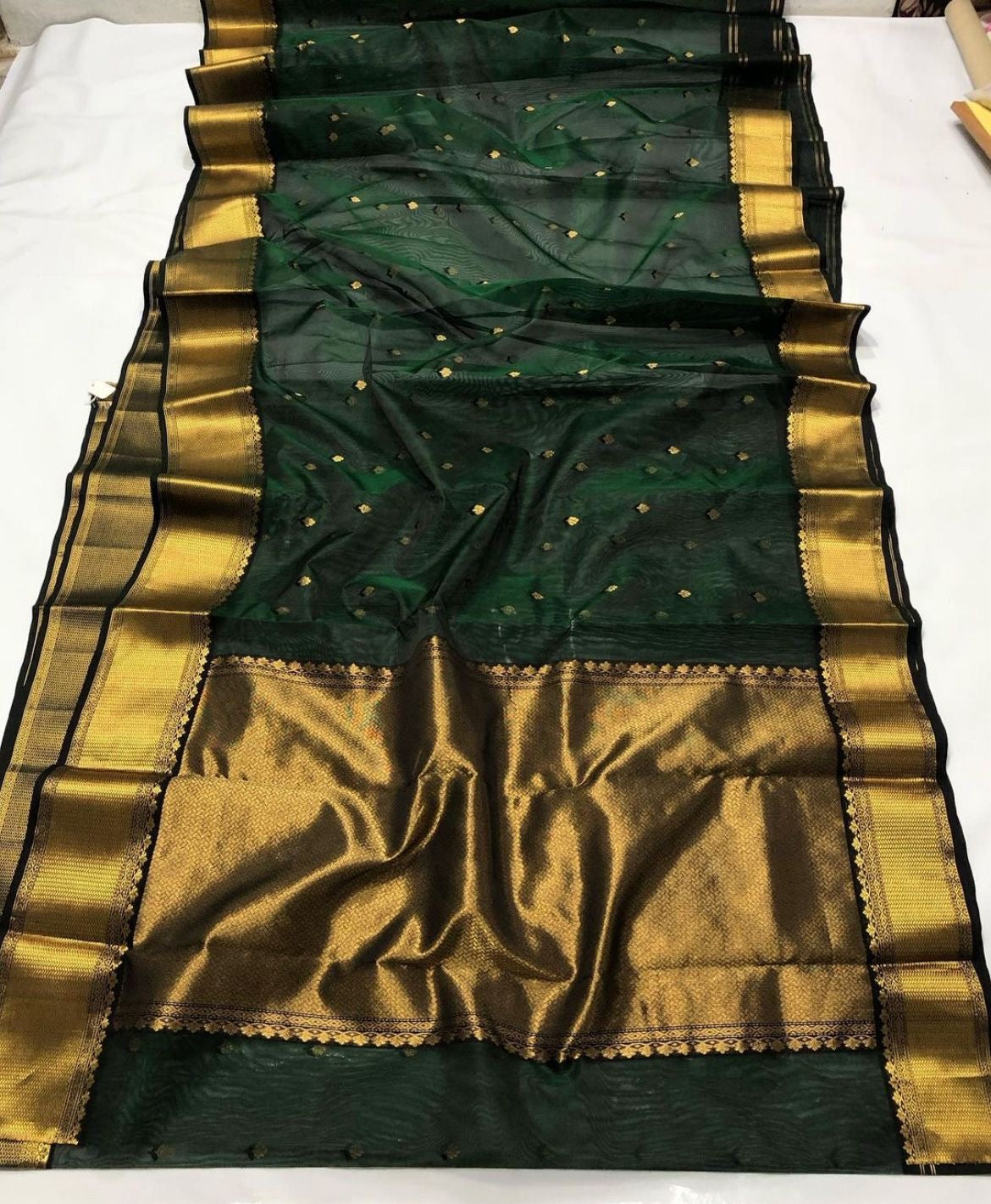 Deep Emerald Green Katan Silk Chanderi saree pallu with expansive antique-gold woven field and fine repeating texture.