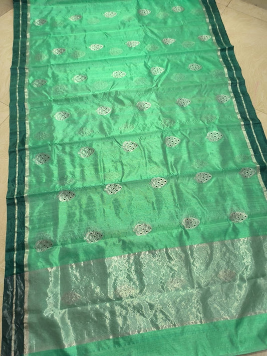 Pure silk Chanderi saree laid flat showing a translucent green body with evenly spaced small woven accents