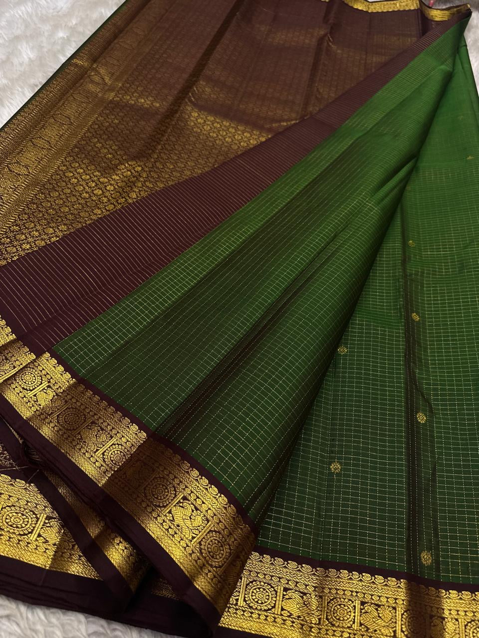 Pure Kanchipuram Silk Saree laid out with deep green checked body, maroon border, and contrasting pallu section visible in the frame.