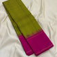 Long folded pure Kanchipuram silk saree showing green-yellow checked body and solid magenta section with thin border lines