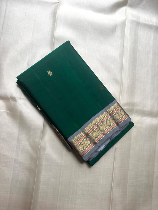 Folded green pure Kanchipuram silk saree with small zari buttas and grey antique gold zari border