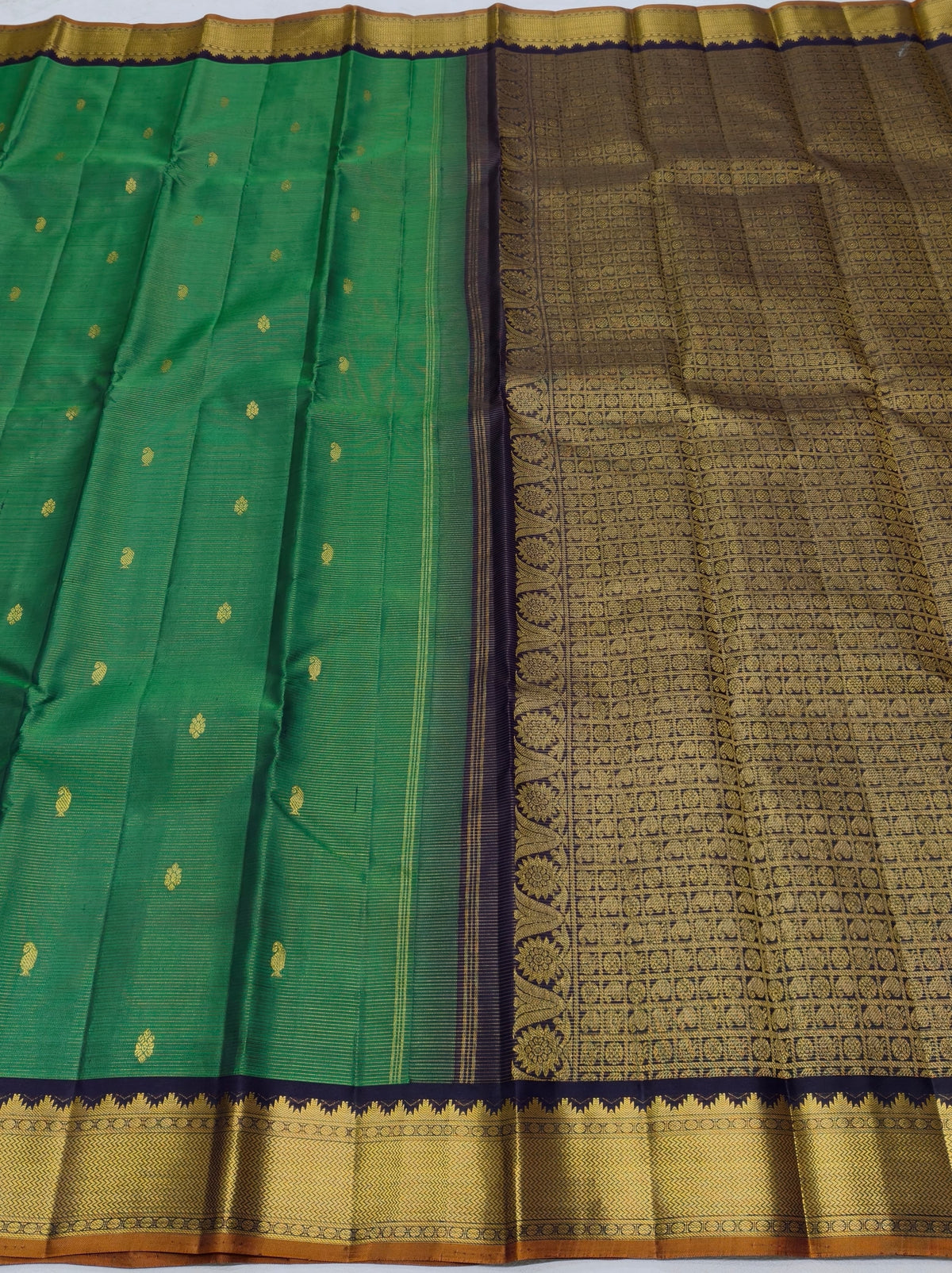 Handwoven Pure Silk Kanjipuram saree in emerald green with navy contrast and richly woven classic-gold zari.