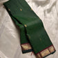 Deep green zari kattam Pure Kanchipuram Silk Saree shown folded with gold motifs and maroon zari woven border