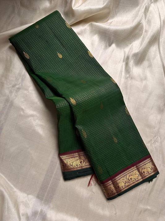 Deep green zari kattam Pure Kanchipuram Silk Saree shown folded with gold motifs and maroon zari woven border