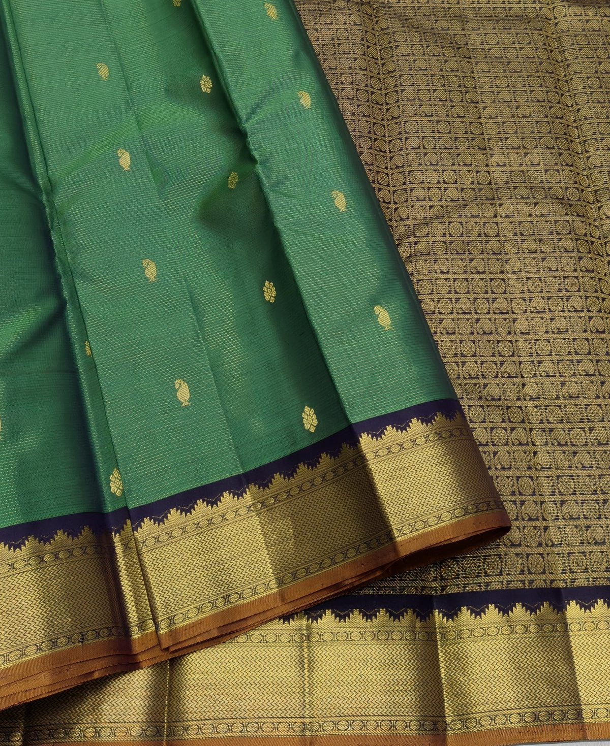 Emerald green Pure Silk Kanjipuram saree with spaced gold zari buttas and a deep navy gold zari border.