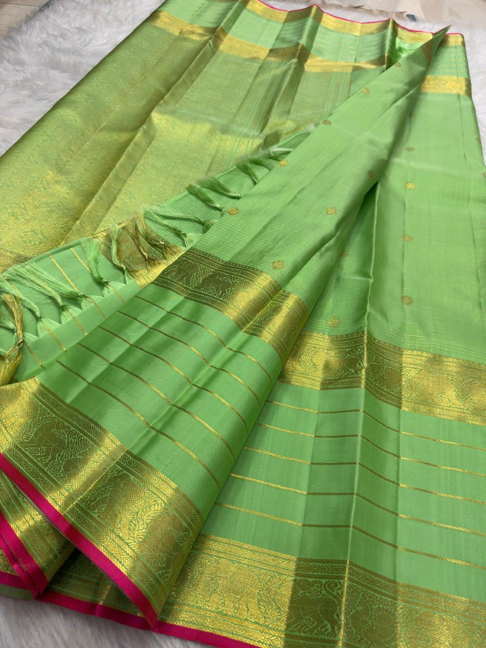 Close view of Kili Pachai green pure silk with individually spaced classic-gold zari buttas across the checked body.