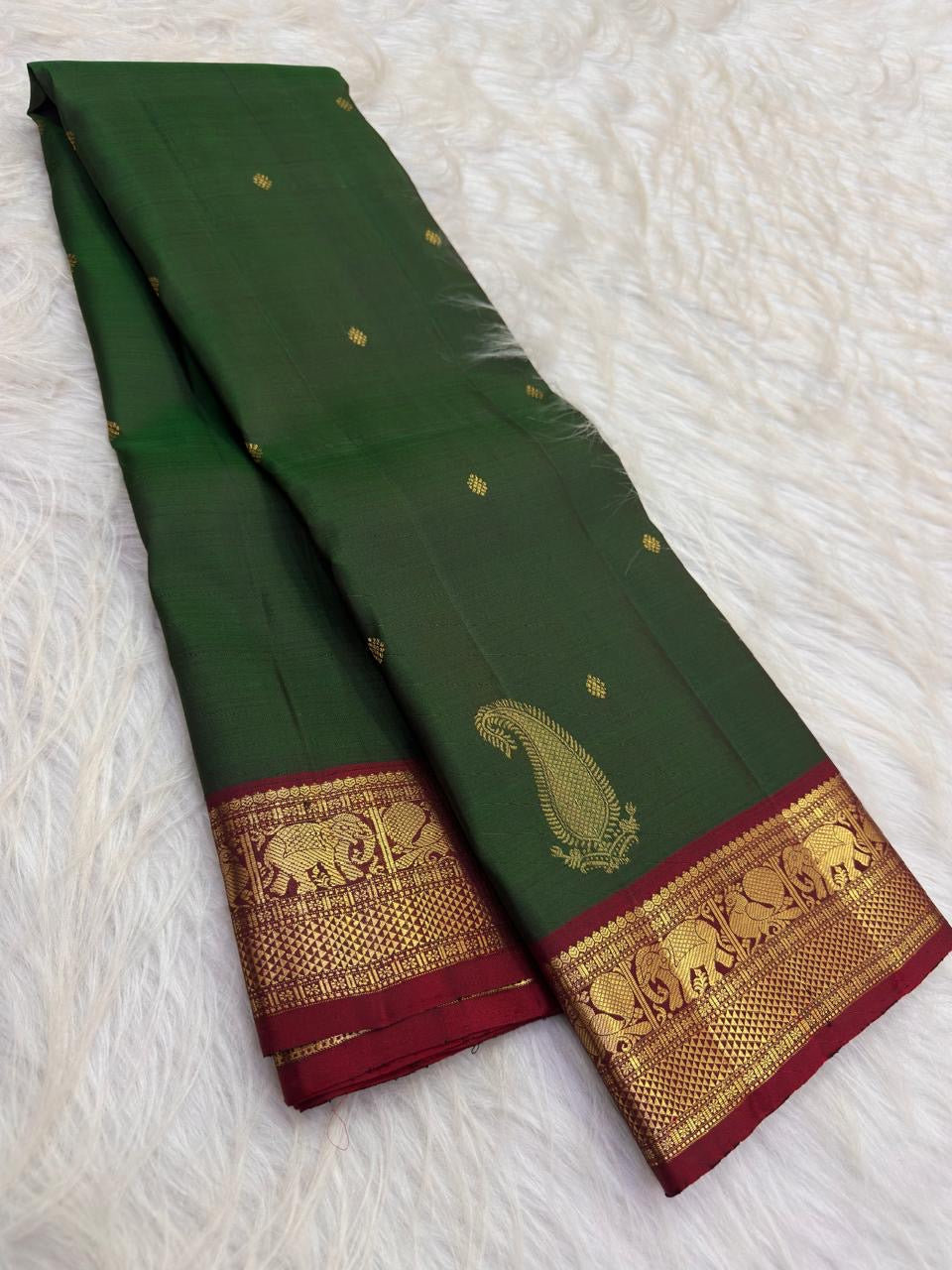 Detail of the saree border: An Arakku red and gold border with a repeated Yaanai register above a closely worked geometric zari base.