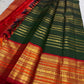 Close view of the green silk body with visible handwoven zari details and traditional border.