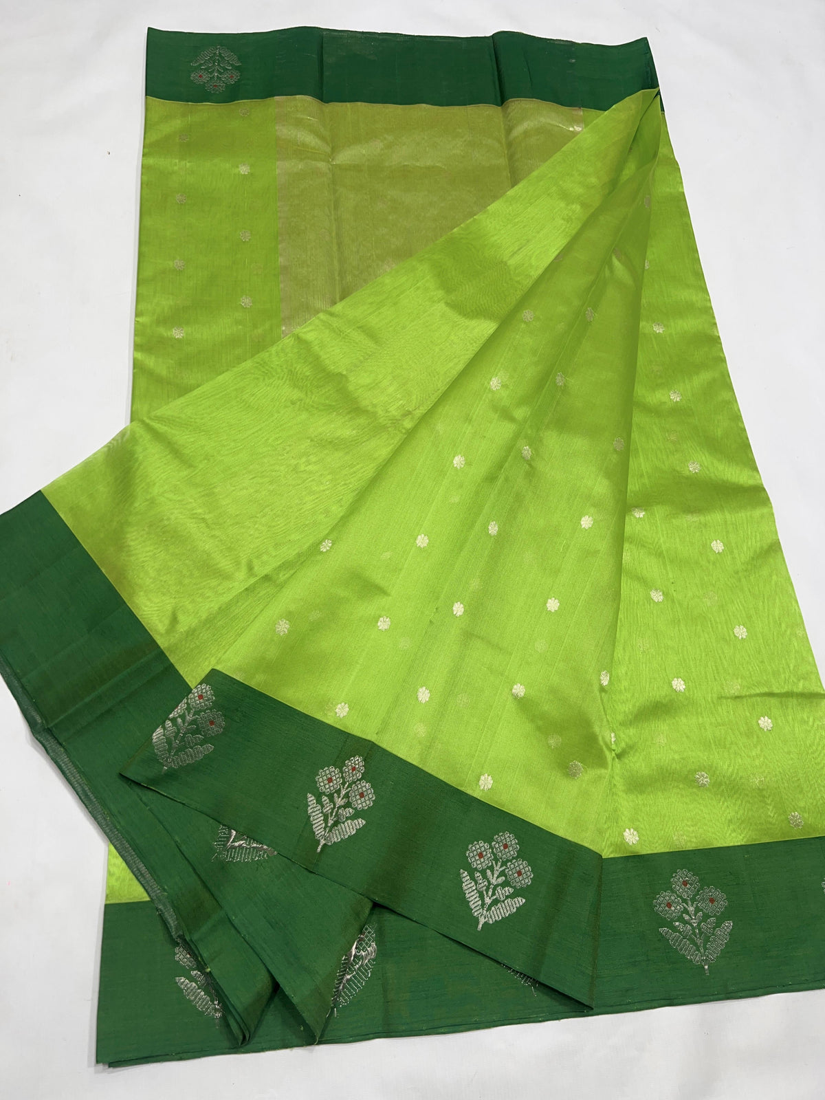 Close-up of the Deep Forest Green floral border on the Parrot Green Pattu Silk Chanderi saree