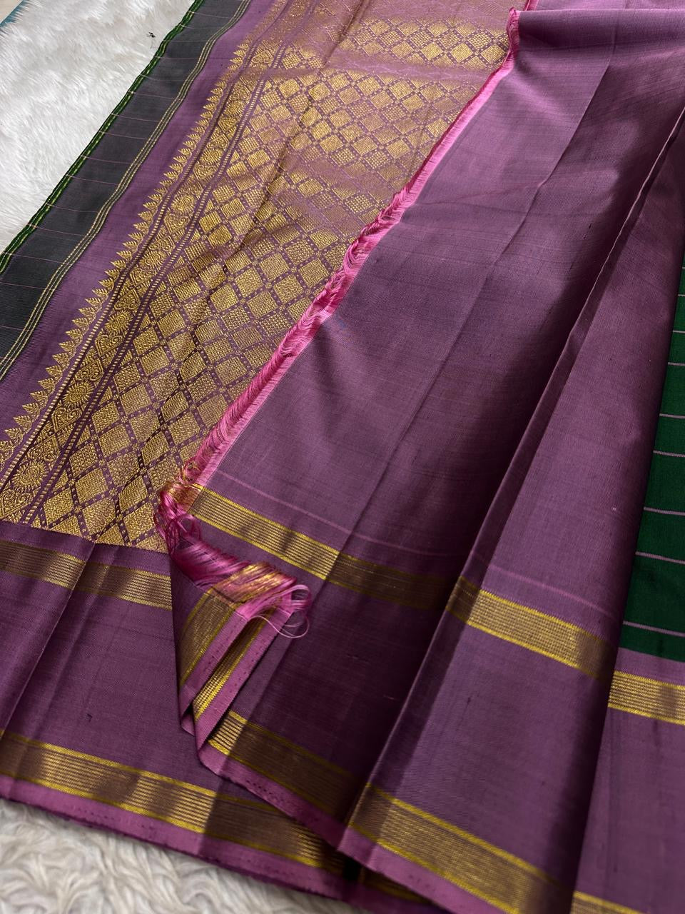 Handwoven green Kanchipuram silk with cool lavender border and richly geometric zari pallu.
