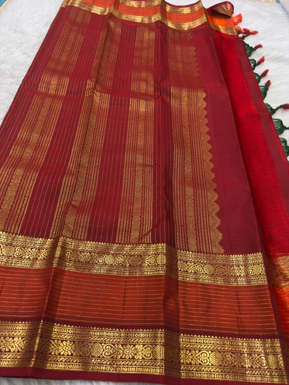 Full drape view highlighting the green body, contrast border and traditional zari workmanship.