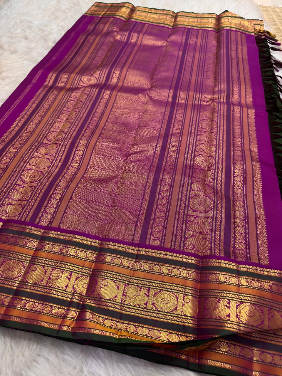 Close view of Kalam paisley buttas on the green silk body of a Kanchipuram saree