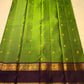 Flat-lay green Pure Kanchipuram silk saree with purple border, gold zari woven bands, and tassel edge, shipped from New Jersey USA