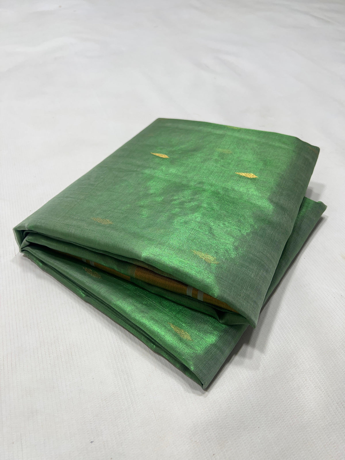Gold circular motifs and silver-toned leaf details on green silk