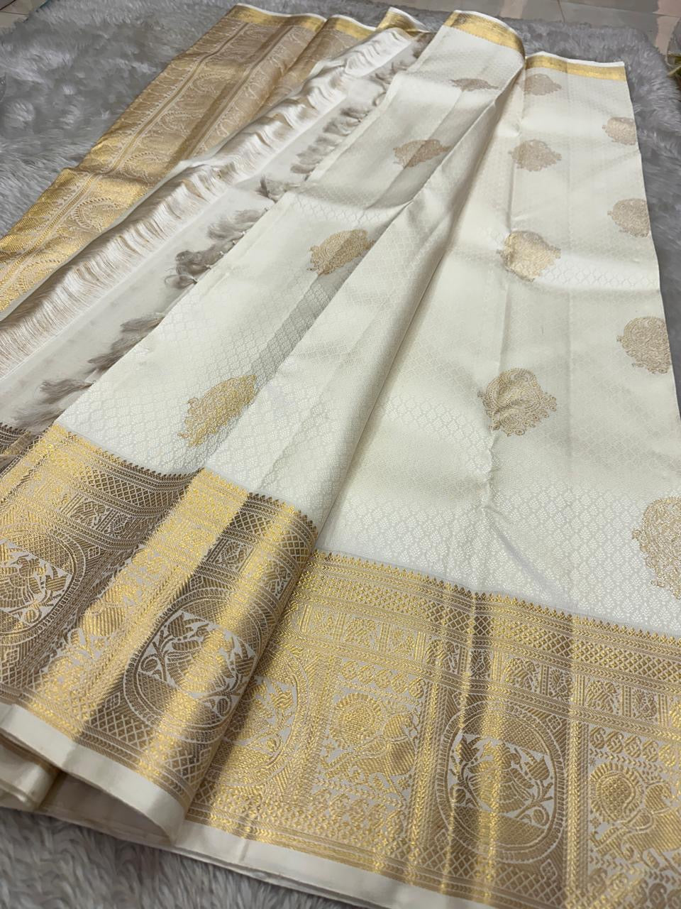 Close-up of gold zari border on ivory Pure Kanchipuram Silk Saree with fine woven texture.