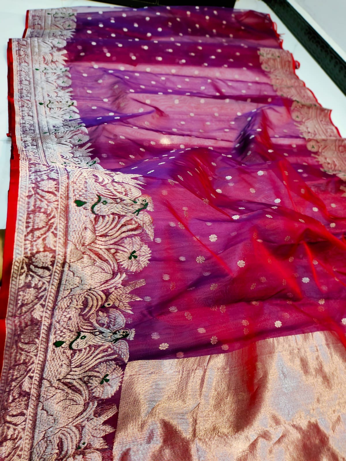 Close detail of the shimmering silver-rose pallu on a berry red Chanderi Katan Silk saree