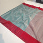 Three-quarter view of mist blue Chanderi Tissue Silk saree with crimson border and gold-toned dots