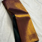 Deep bottle green Kanchipuram pure silk saree draped, showing the copper-gold border