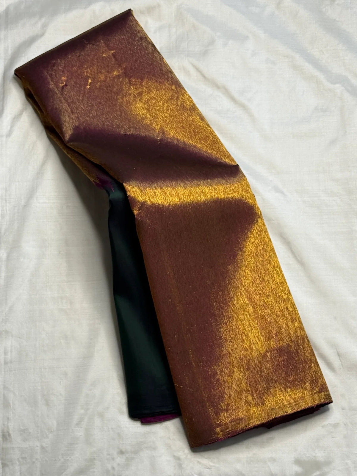 Deep bottle green Kanchipuram pure silk saree draped, showing the copper-gold border