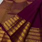 Deep cherry red Kanjivaram saree showing the contrast between its circular body buttas and rich gold pallu.