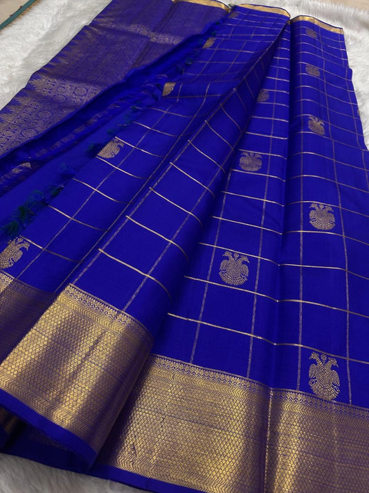 Grand antique gold zari pallu on Royal Blue Zari Kattam Kanchipuram saree with densely woven geometric ornamental detailing.