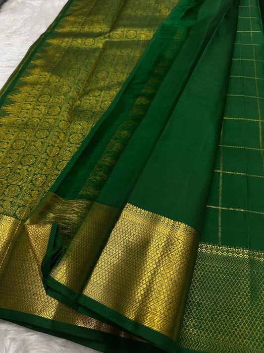 Grand antique gold zari pallu of deep emerald green Zari Kattam Kanchipuram silk saree with intricate geometric handwoven patterning.