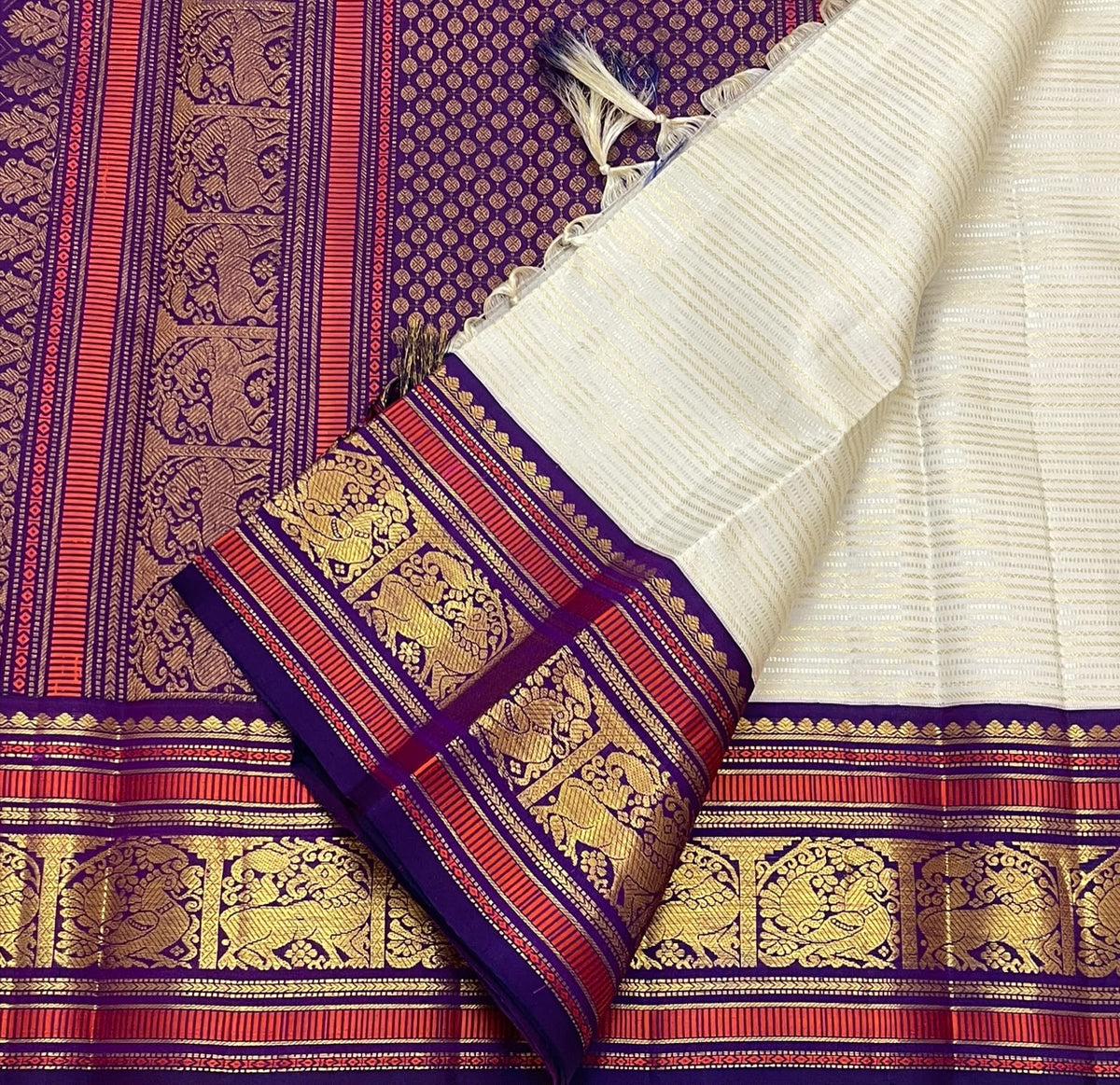 Warm Ivory Handwoven Pure Silk Kanchipuram Saree with Purple Border and Veldhari Detail, silk body close-up