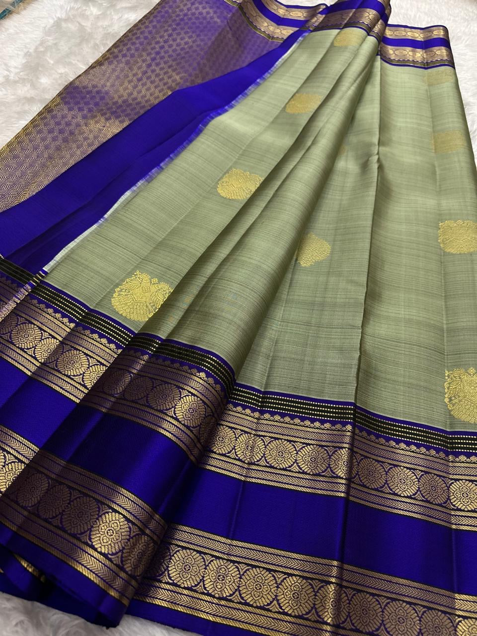 Close-up of Gandaberunda zari motifs on the sage green Kanchipuram Butta saree.