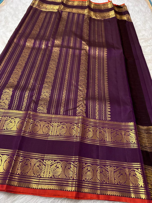 Peacock-plumage Rettapet border with double zari bands on a deep purple handwoven Kanchipuram silk saree