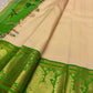 Emerald green Korvai border detail with antique-gold zari peacock motifs on soft ivory Kanjipuram saree