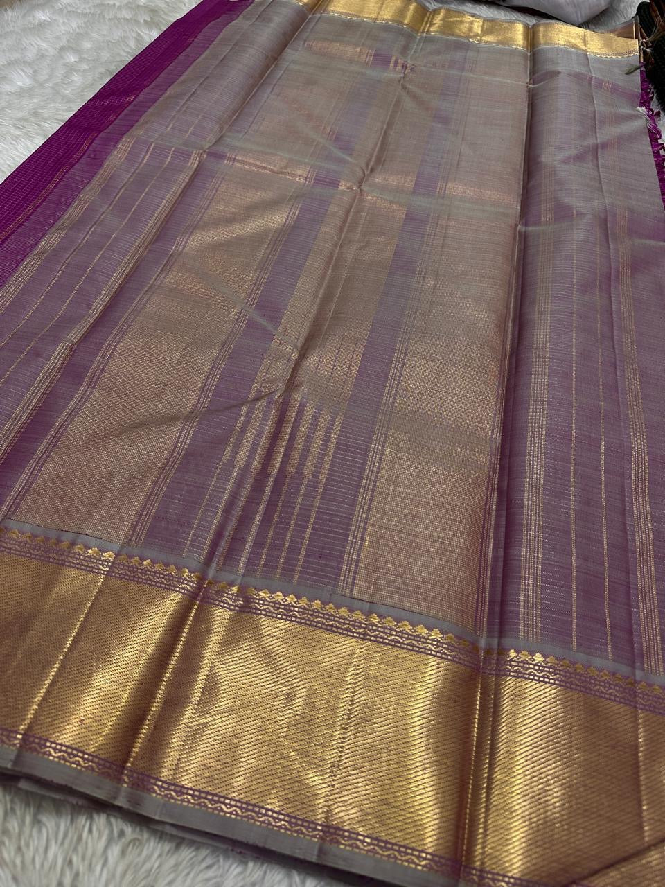 Handwoven magenta Kanchipuram saree with gold zari and a contrasting pallu.
