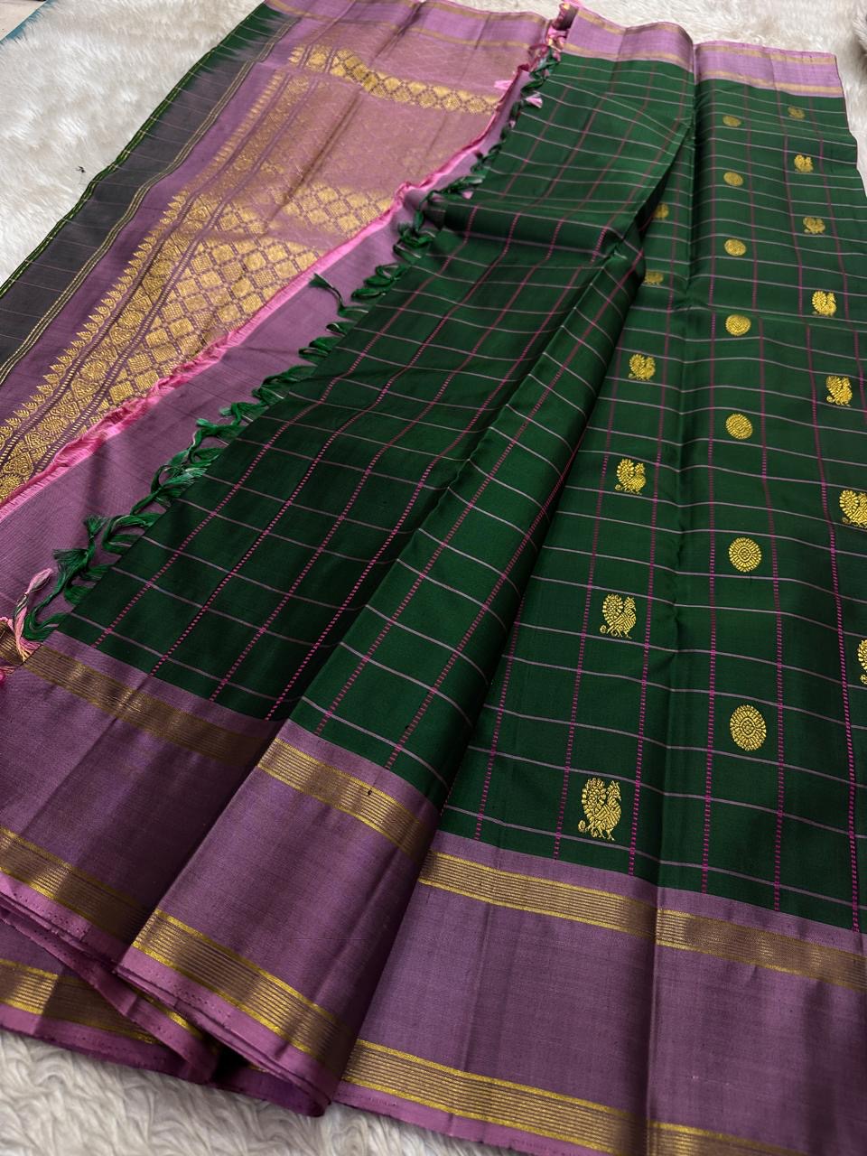 Maragatham-green handwoven Kanchipuram saree showing geometric zari grid and traditional buttas.